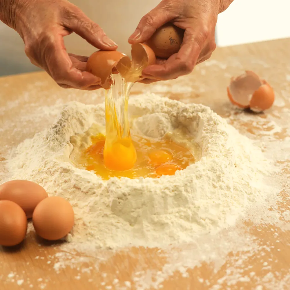 Eggs cracked into a well of flour
