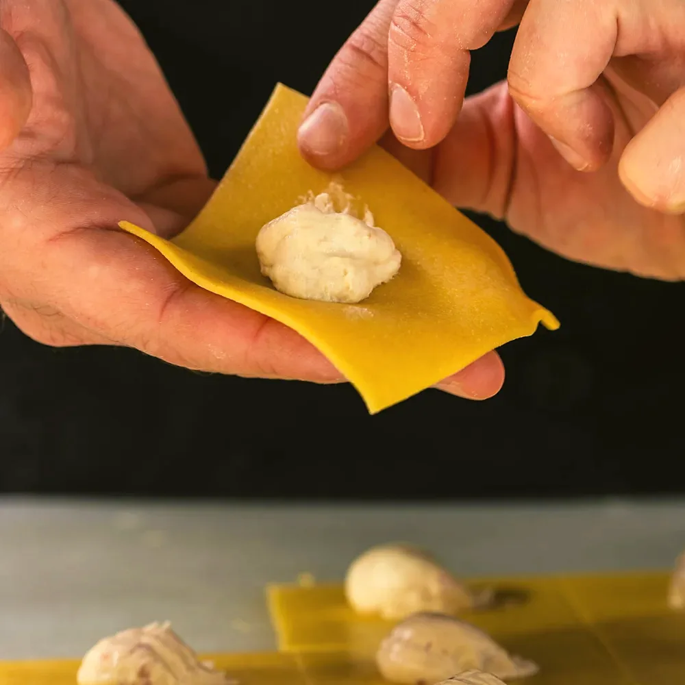 Filling fresh ravioli by hand